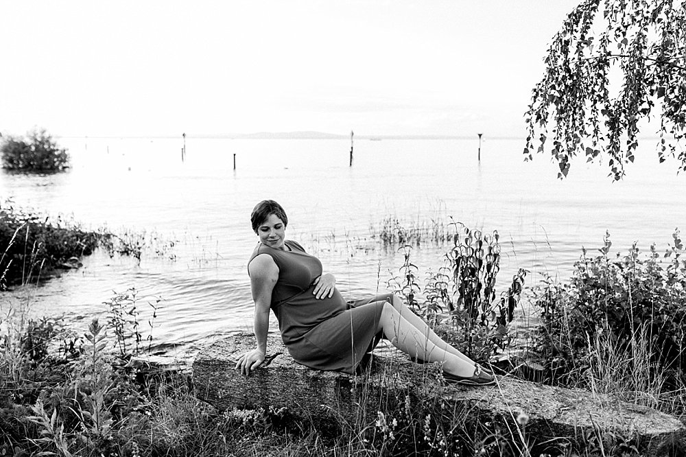 Schwangere Frau posiert am Seeufer - schwarzweiß